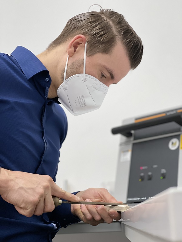 material-ueberpruefung-analyse Mann mit Maske prüft Materialien
